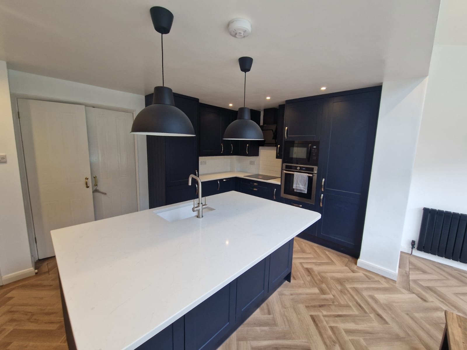 Deep blue shaker kitchen with large white island